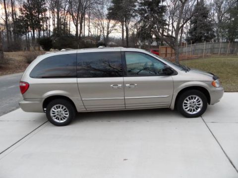 1985 Yugo GVX - Side view of a tan minivan parked on a concrete driveway during the day.
