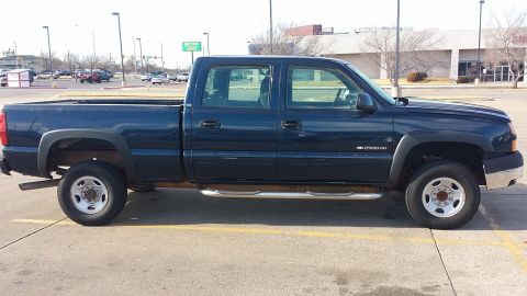 1985 Yugo GVX - A dark blue pickup truck is parked in a lot, viewed from the side. The truck appears to be a Chevrolet Silverado 2500 HD.