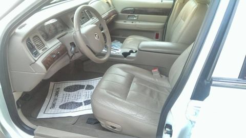 2000 Mercury Grand Marquis - The interior of a 2000 Mercury Grand Marquis is shown, tan leather seats and a clean floor mat.