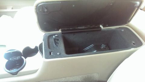 2000 Mercury Grand Marquis - Interior view of a vehicle's center console, showing the armrest storage and an ashtray.
