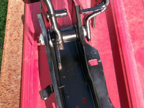 1967 Ford Mustang - Close-up of a car part, likely a hinge mechanism, with visible metal and chrome components.