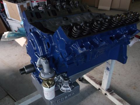 1967 Ford Mustang - A blue engine block with visible valve springs and a fuel pump is mounted on an engine stand.