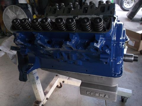 1967 Ford Mustang - A freshly painted blue engine block sits on a stand, showing its internal valve components and a "COBRA" branded oil pan.