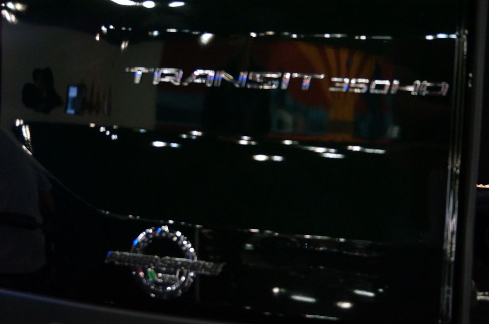 Chrome badge on a black vehicle reads TRANSIT 350HD. A circular emblem is below it