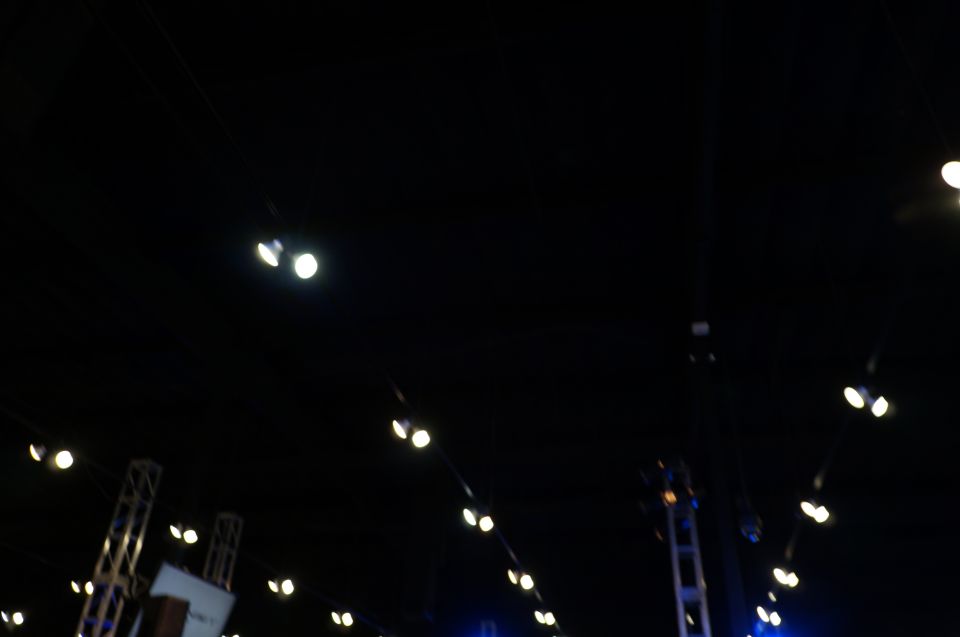 Dark scene with multiple spotlights and stage rigging