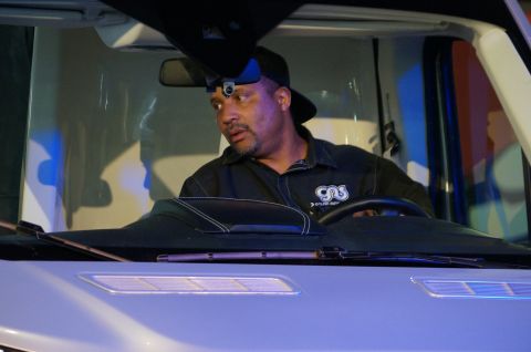 1993 Ford Taurus - A man is inside the cab of a truck, wearing a headlamp and looking away from the camera.