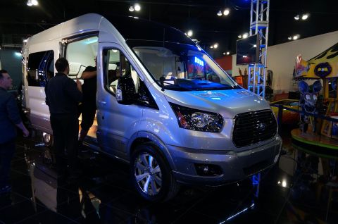 1993 Ford Taurus - Silver Ford Transit van with black roof and tinted windows on display.