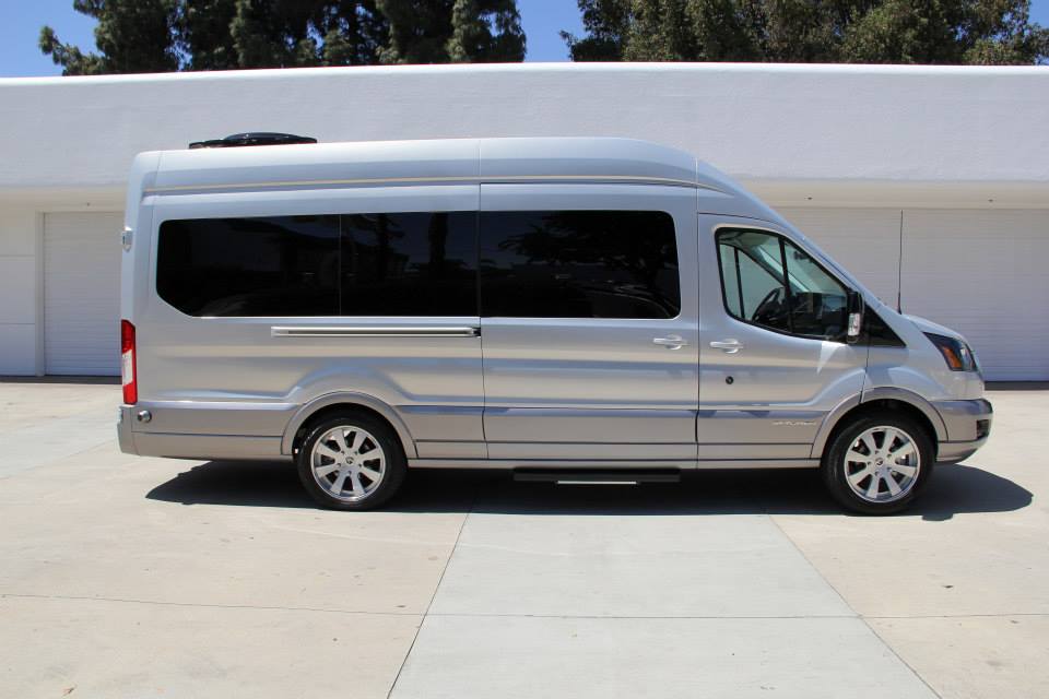 Silver van with tinted windows and a sliding door, seen from the side