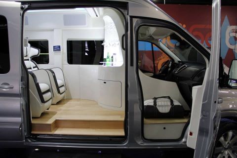 1993 Ford Taurus - Custom interior of a van two rows of plush white seats and a polished wood floor.