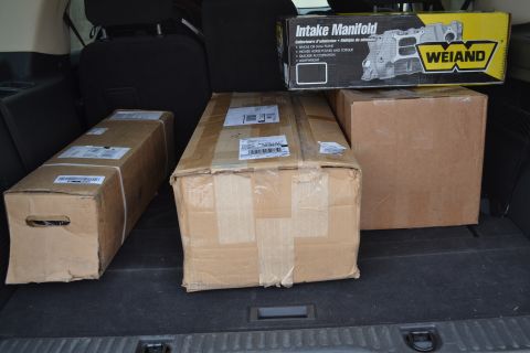 1981 Ford F-250 - Boxes and a Weiand intake manifold are loaded into the cargo area of a vehicle.