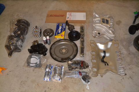 1981 Ford F-250 - Collection of engine components, including crankshaft, pistons, and manifolds, arranged on a floor.