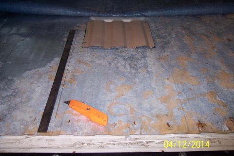 1990 Ford Bronco - A utility knife and ruler are positioned on a vehicle's interior floor, ready to cut an access panel.