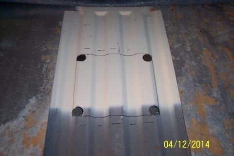 1990 Ford Bronco - A metal panel with cutouts and drawn lines is shown, likely a part for a vehicle.