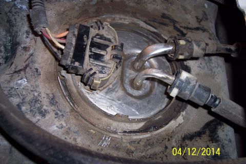 1990 Ford Bronco - Close-up of a vehicle's fuel pump module, showing the connector and fuel lines.