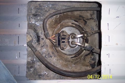 1990 Ford Bronco - Close-up view of a vehicle's fuel pump assembly, showing the pump, fuel lines, and electrical connector.