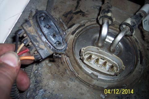 1990 Ford Bronco - Disconnected fuel pump electrical connector and fuel lines attached to the fuel tank assembly.