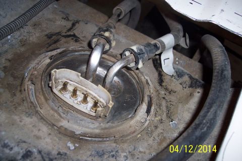 1990 Ford Bronco - Close-up view of a vehicle's fuel pump assembly, showing the electrical connector and fuel lines.