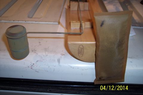 1990 Ford Bronco - A Ford fuel sender assembly with a new fuel filter sock is shown, likely for replacement.
