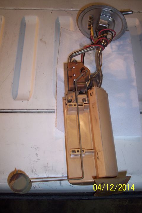 1990 Ford Bronco - A disassembled fuel pump assembly is shown, with visible wiring and a float mechanism.