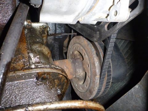 1964 Mercury Monterey - Close-up view of a greasy engine pulley and belt system.
