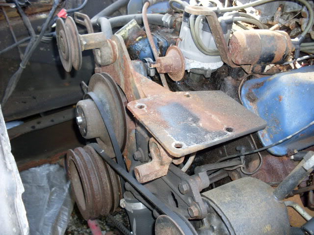 Engine pulleys and belts on a rusty bracket