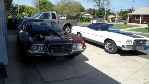 1972 Ford Ranchero - Two Ford Rancheros, one maroon and one white, are parked in a driveway with a pickup truck behind them.