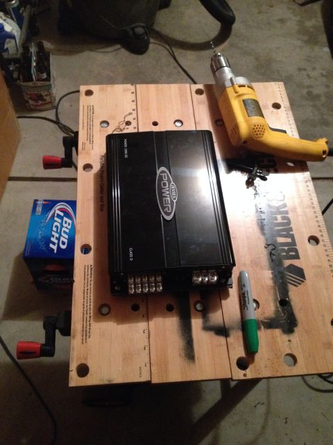 2005 Jeep Wrangler - A car amplifier, drill, and a pack of beer are laid out on a workbench.