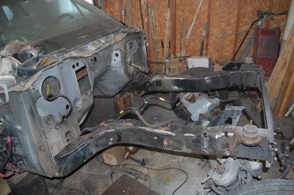 Bare truck frame and firewall during a body-off restoration in a garage