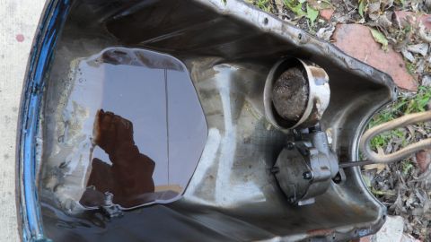 1972 Ford Ranchero - Oil pan containing dark oil and an oil pump assembly.