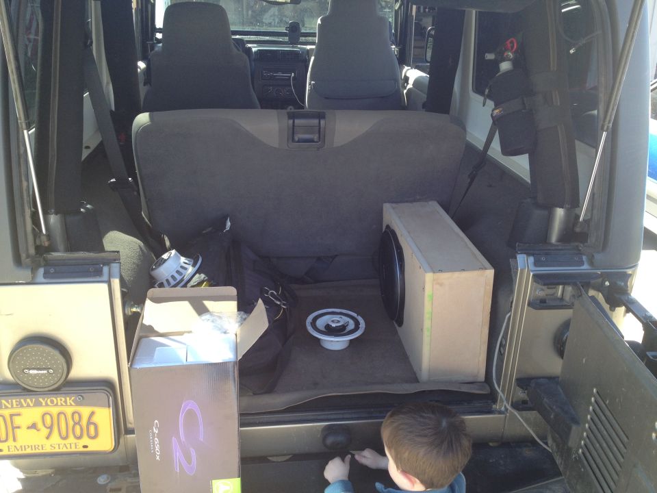 Interior of a 2005 Jeep Wrangler with a subwoofer box and speakers