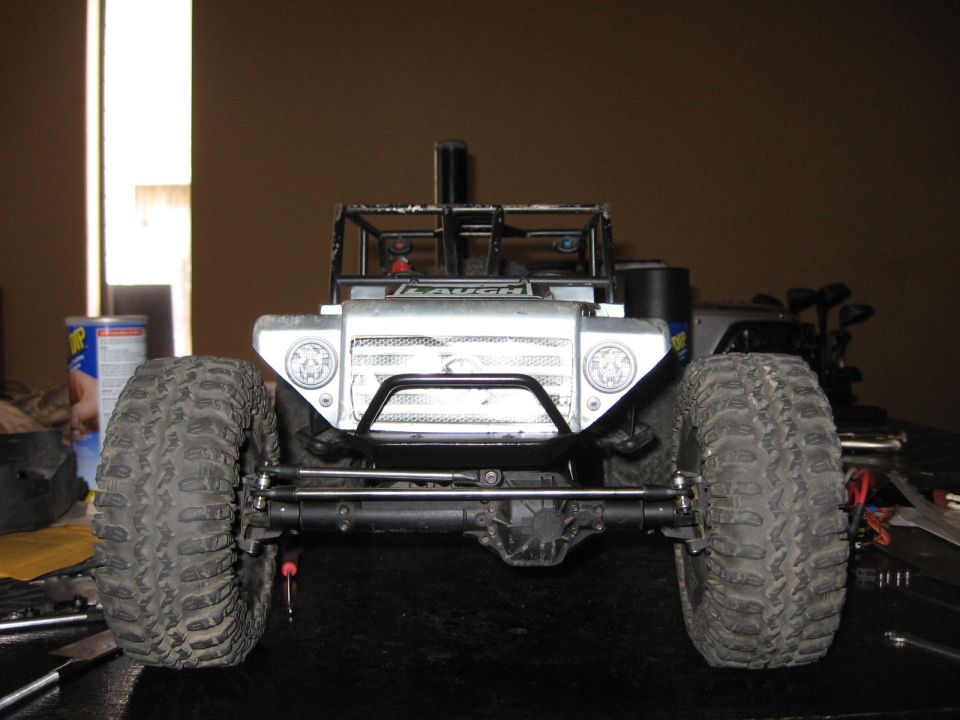 Silver toy RC car front view with large tires and roll cage