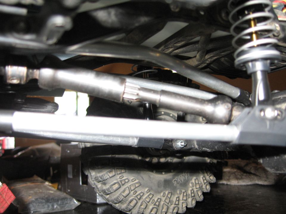 Undercarriage of a vehicle with a driveshaft, suspension, and tire visible