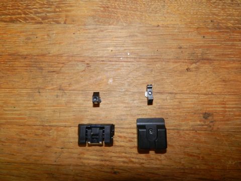 1996 Ford Bronco - Four black plastic automotive clips are displayed on a wooden surface.