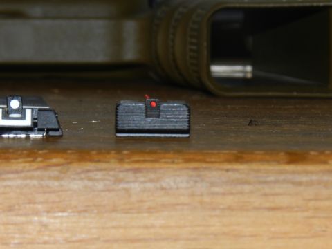 1996 Ford Bronco - Close-up of two gun sights, one a red dot sight, resting on a wooden surface.