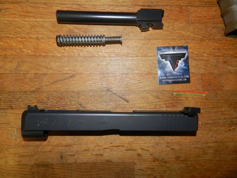 1996 Ford Bronco - Disassembled firearm components laid out on a wooden surface with a business card and small rods.