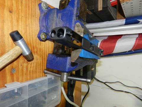 1996 Ford Bronco - A firearm is secured in a vise, with a hammer positioned to its left, suggesting a repair or modification.