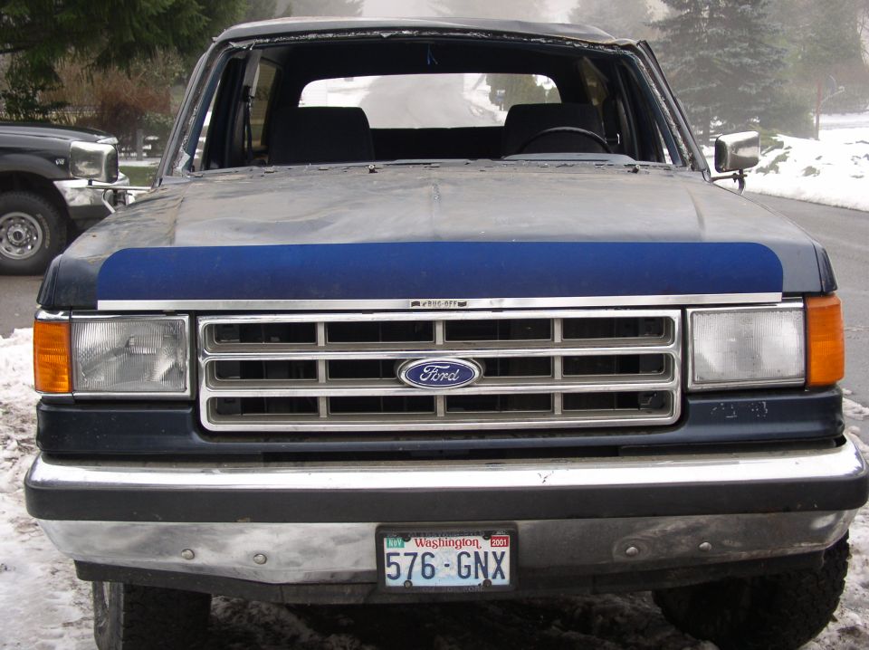 Front view of a dark blue 1988 Ford Bronco with a chrome grille and Washington license plate 576-GNX