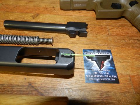1996 Ford Bronco - Handgun components laid out on a wooden table next to a business card for Taran Tactical Innovations.