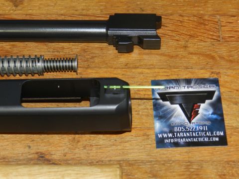 1996 Ford Bronco - Disassembled firearm components laid out on a wooden surface with a business card for Taran Tactical Innovations.