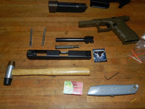 1996 Ford Bronco - Disassembled handgun components and tools are arranged on a wooden table.