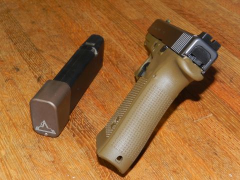 1996 Ford Bronco - A tan pistol with an extended magazine rests on a wooden surface.