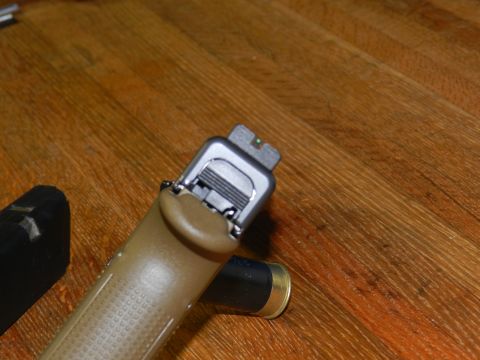 1996 Ford Bronco - Close-up of a pistol's slide and grip, resting on a wooden table.