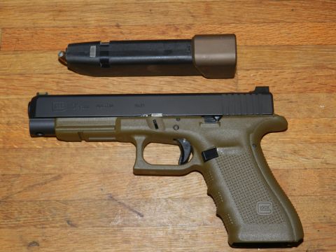 1996 Ford Bronco - A Glock pistol with an extended magazine is displayed on a wooden surface.
