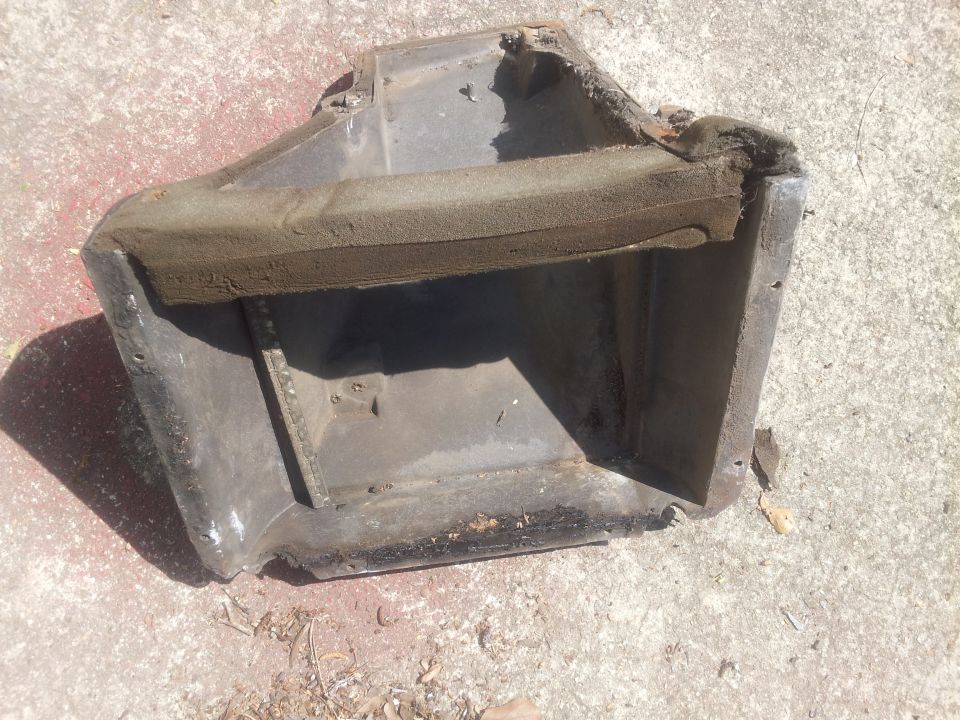 Metal air conditioning duct housing with foam seal, resting on concrete