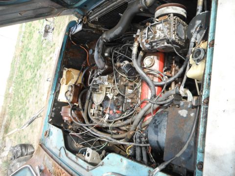 1972 International Scout II - The engine bay of a 1972 International Scout II reveals its V8 engine, carburetor, and radiator, the mechanical components.