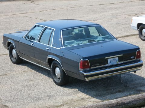 1991 Ford LTD Crown Victoria - Rear three-quarter view of a dark blue Ford LTD Crown Victoria sedan parked along a curb.