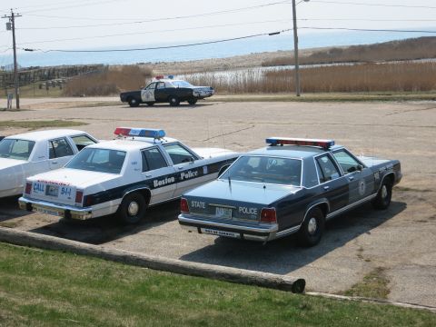 1991 Ford LTD Crown Victoria - Boston Police cruiser and a State Police sedan parked rear-in, with a Highway Patrol car behind near the shore.
