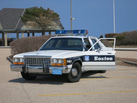 1991 Ford LTD Crown Victoria - white and blue Boston Police Ford LTD Crown Victoria with front doors open, parked at a paved lot near a pavilion.