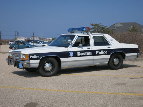 1991 Ford LTD Crown Victoria - Boston Police Ford LTD Crown Victoria sedan shown in driver-side profile in a beachside parking lot.