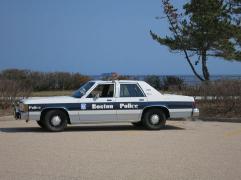 1991 Ford LTD Crown Victoria - Boston Police Ford LTD Crown Victoria sedan in driver-side profile parked at a lot overlooking the ocean.